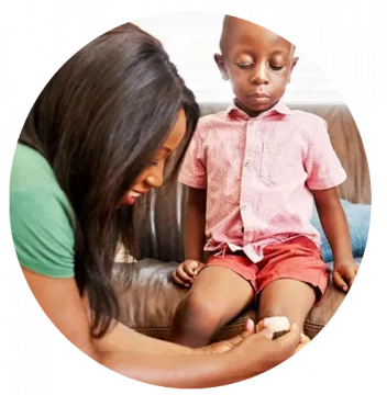 A woman treating a child's scrape.