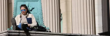 Columbia student studying on steps of Low Library on campus