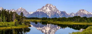 Mountains of Teton range reflecting in a pond at Oxbow Bend in Grand Teton National Park