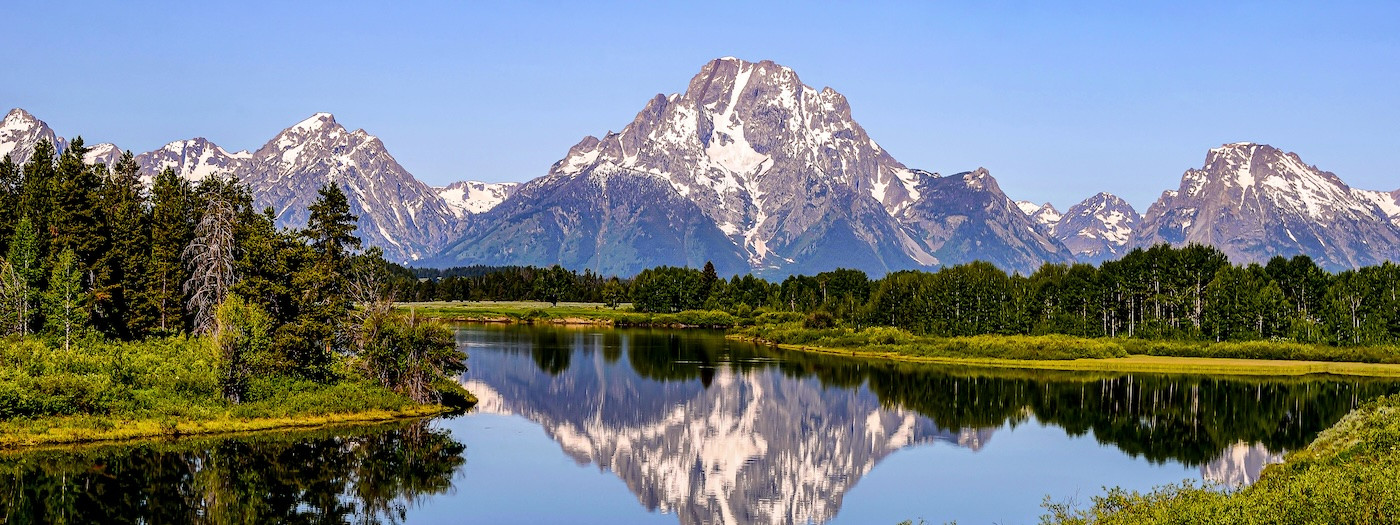 Mountains of Teton range reflecting in a pond at Oxbow Bend in Grand Teton National Park