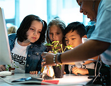students look at a plant at community day