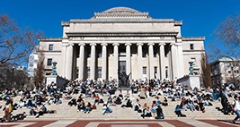 students sitting in front of low library on the steps