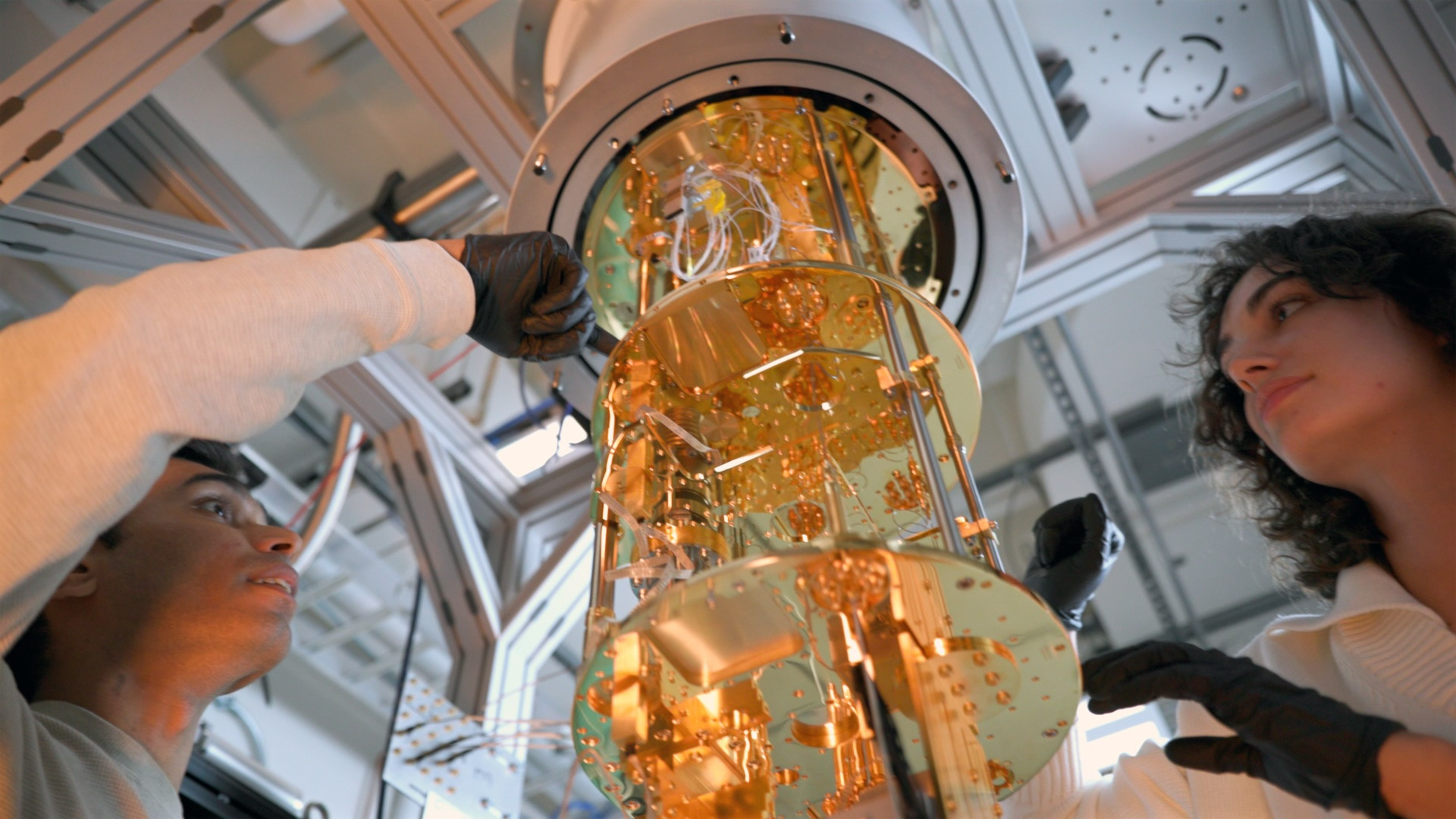 Students in Xueyue (Sherry) Zhang’s lab examine a dilution refrigerator holding superconducting quantum circuits